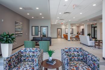 a lobby with couches and chairs and a table with a plant